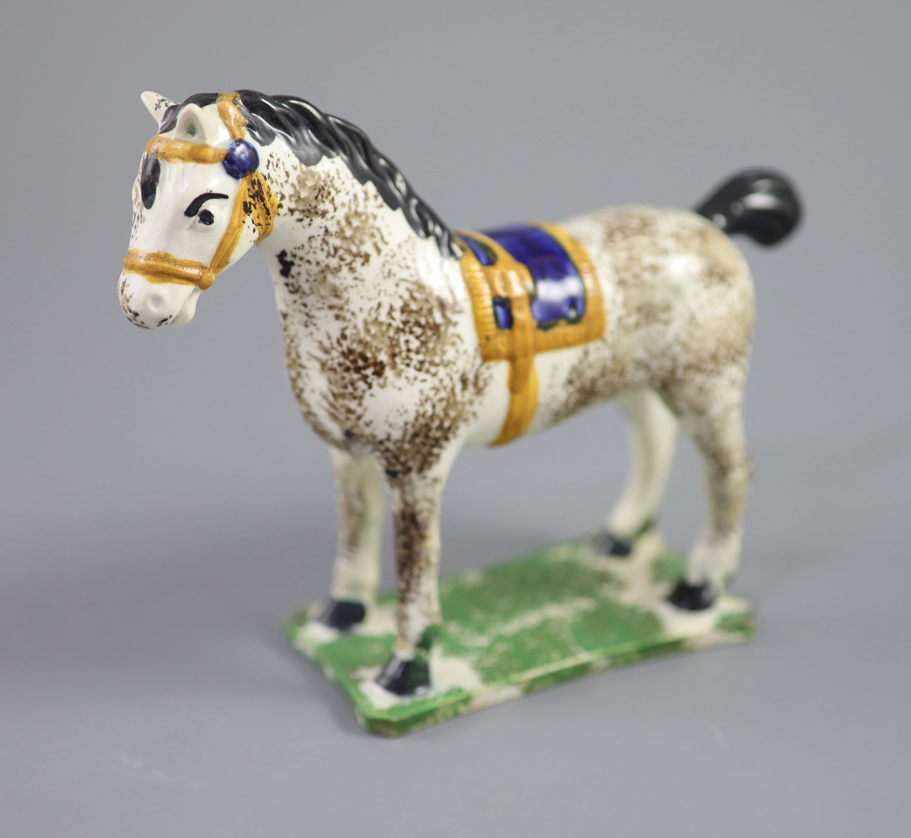 A North Country pearlware figure of a dapple horse with blue saddle, c.1800-20 14.5cm high